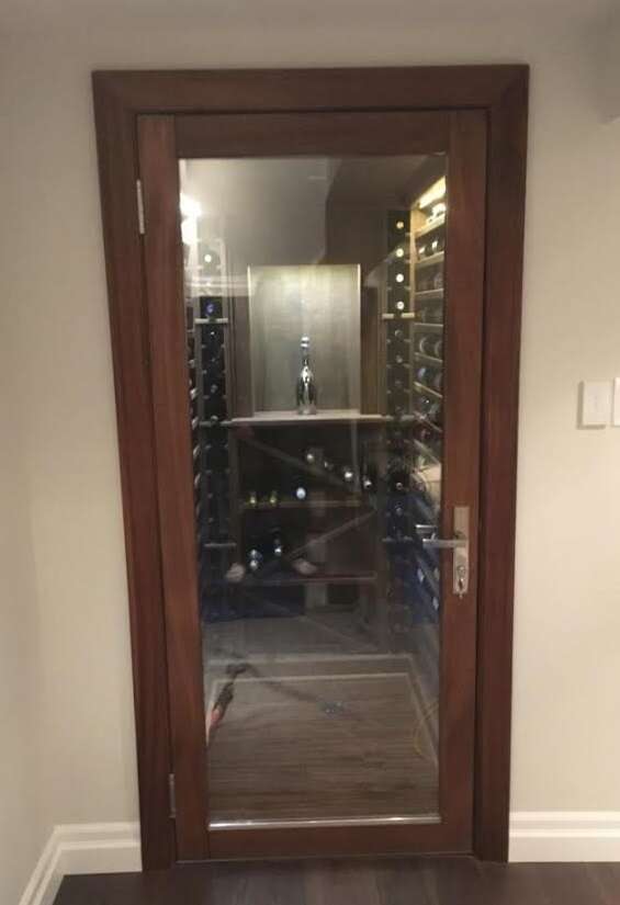 VWC custom wine racking, maximizing the small space, featuring LED lighting system and custom thermopane door with full tempered, glass insert.