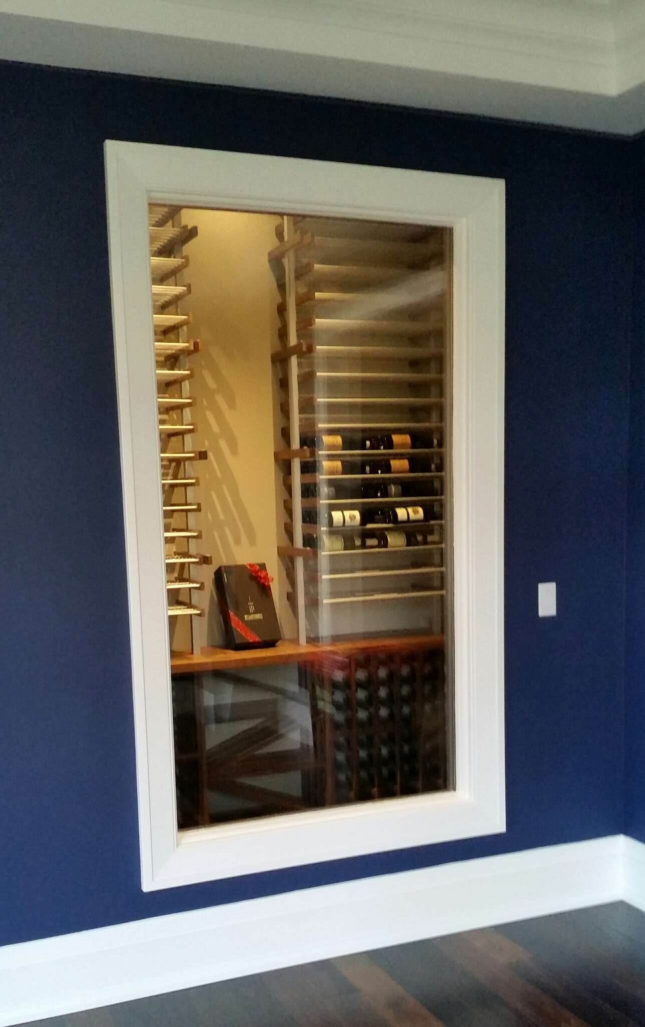 Custom wine room featuring ductable cooling system, EVO racking system and cabinetry.